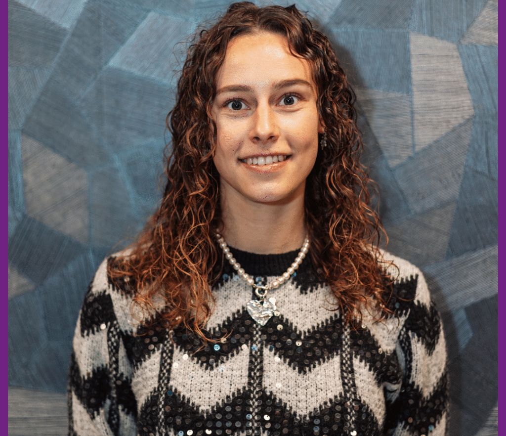 Nieuwe collega Anne bij PohlCon Benelux, lachend voor een blauwe achtergrond